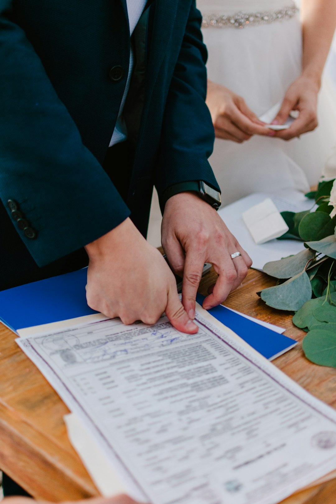couple-signing-marriage-license-during-wedding-ceremony-oj25pnimigs
