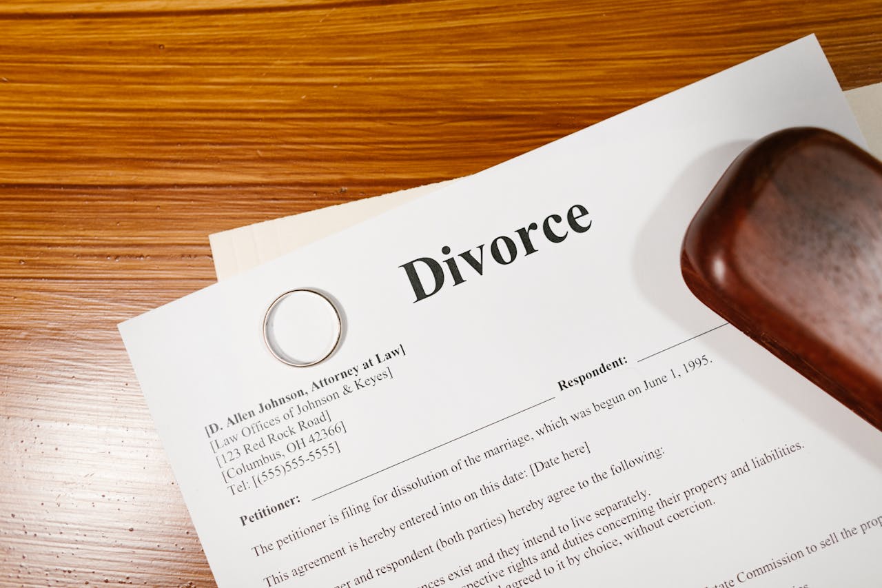 Close-up of a divorce document and wedding ring on a lawyers desk.